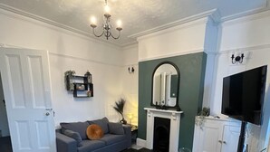 A living room with a fireplace, a television, and a sofa. - Contractors - Families - Couples - 3x Bedrooms + Sofa Bed - Sleeps 8 M1 J26&25 (Ilkeston)