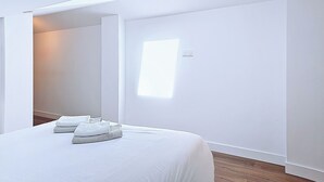A bedroom with a bed, a window, and a door. - Appartement Le New-york, Chill & Relax ! (Cholet)
