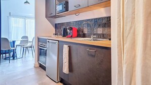 A modern kitchen with a dishwasher, a coffee maker, and a microwave. - Appartement Le New-york, Chill & Relax ! (Cholet)