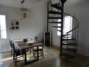 Enjoy meals in this stylish dining area with a wooden table and black chairs, illuminated by a pendant light.