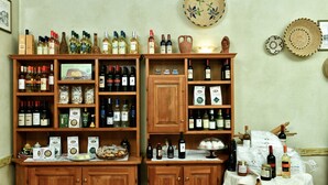 A wine cellar with wooden shelves stocked with various wine bottles and boxes. - Calajunco1985 Sardinia Travel Experience (Loiri Porto San Paolo)
