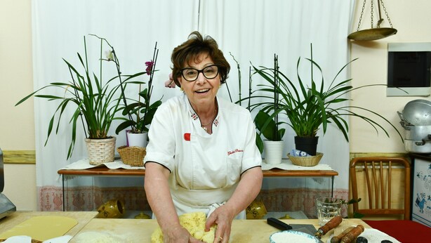 A person kneading dough at a table with various baking tools and ingredients. - Calajunco1985 Sardinia Travel Experience (Loiri Porto San Paolo)