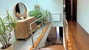 Een modern interieur met een trap, houten meubels en potplanten.