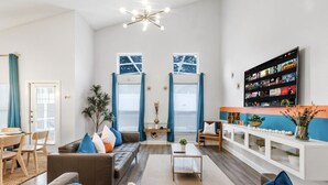 Een moderne woonkamer met een bank, salontafel en een aan de muur bevestigde televisie.