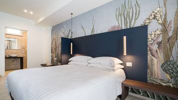 Une chambre moderne avec un grand lit, un banc intégré et une fresque murale représentant des plantes marines.
