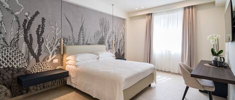 Una habitación de hotel moderna con una cama grande, un escritorio y un mural en la pared.