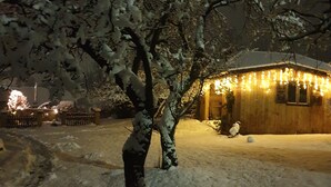 A snow-covered landscape with a wooden building illuminated by string lights. - Appartement mit gr. Garten u. 2 Bäder (Vilshofen an der Donau)