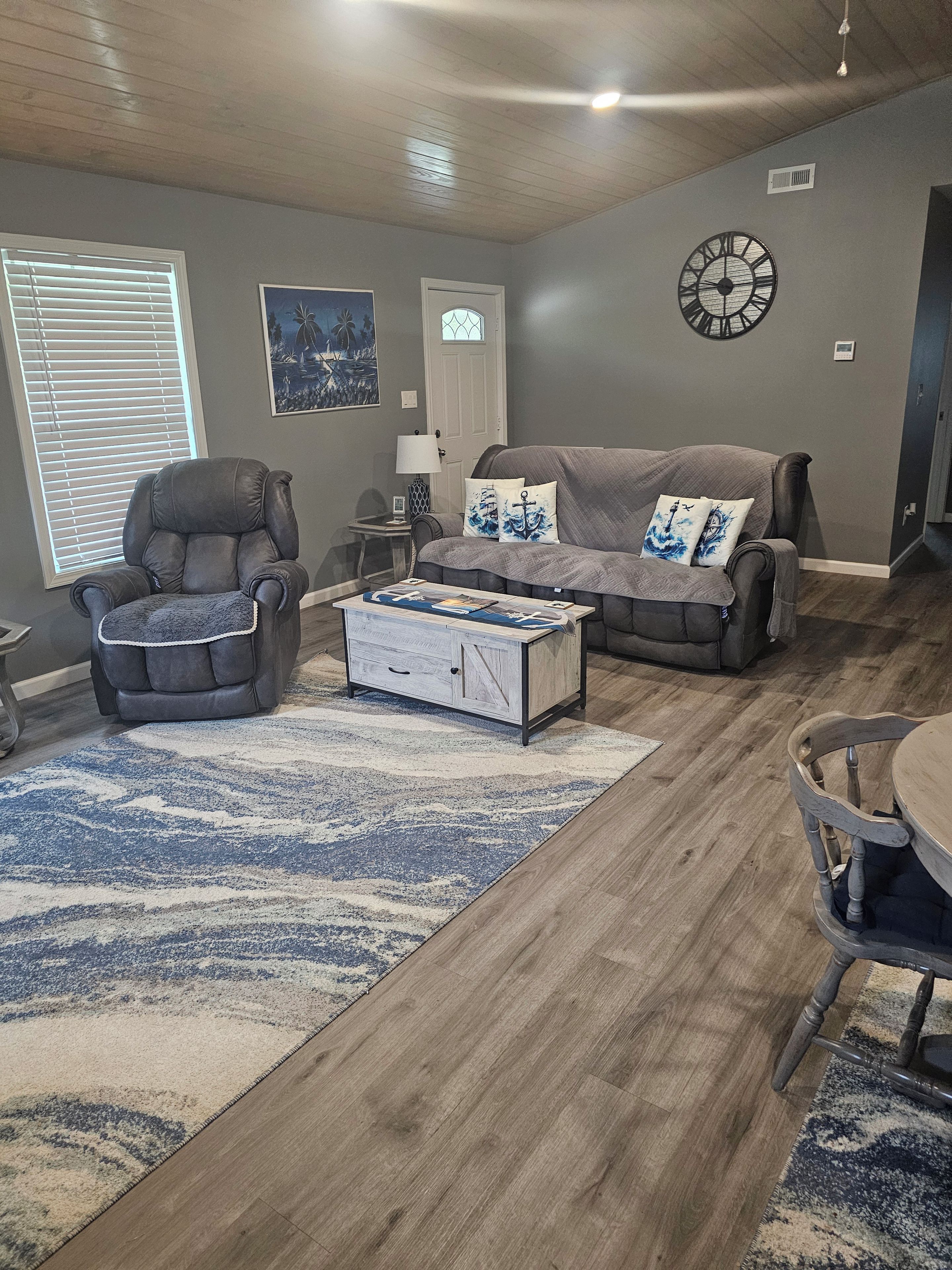 Un salon comprenant un fauteuil en cuir, un canapé, une table basse et un tapis.