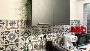A kitchen with a grey cabinet, patterned tiles, a red toaster, and a coffee machine. - 35m2# Luxe#chateau#insead#bestodblo (Fontainebleau)
