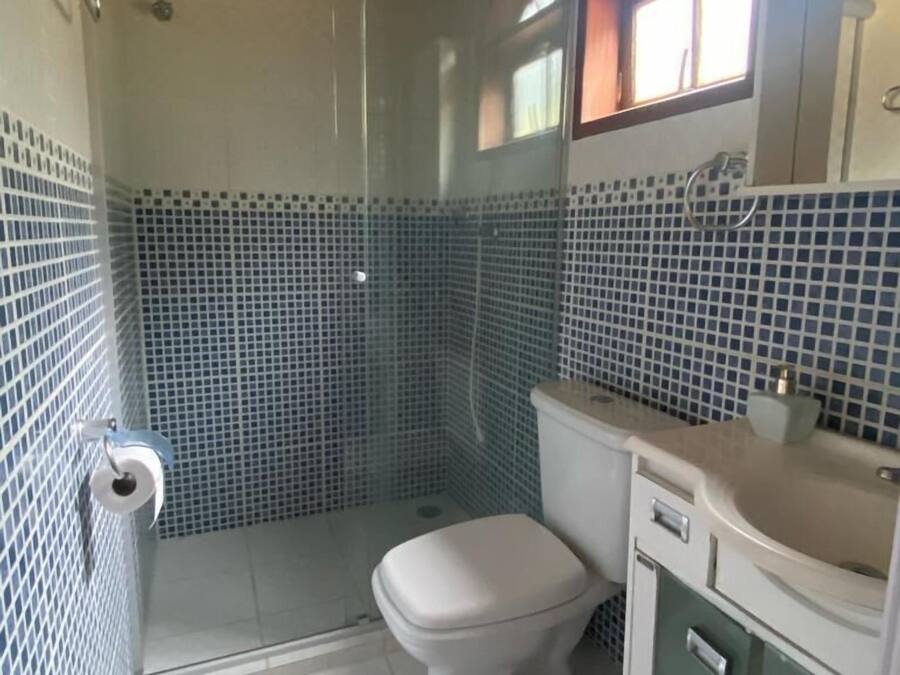 Un baño con ducha, inodoro y lavabo.