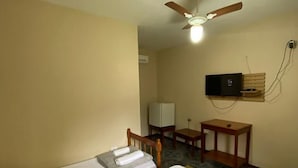 A hotel room with two beds, a ceiling fan, a TV mounted on the wall, and a small table. - Estalagem São Gonçalo  (Paraty)
