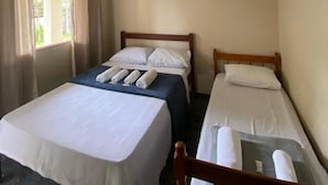A room with two beds, a ceiling fan, and a window with curtains. - Estalagem São Gonçalo  (Paraty)