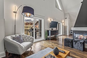Una sala de estar moderna con chimenea, un sofá, una mesa de centro y un televisor.