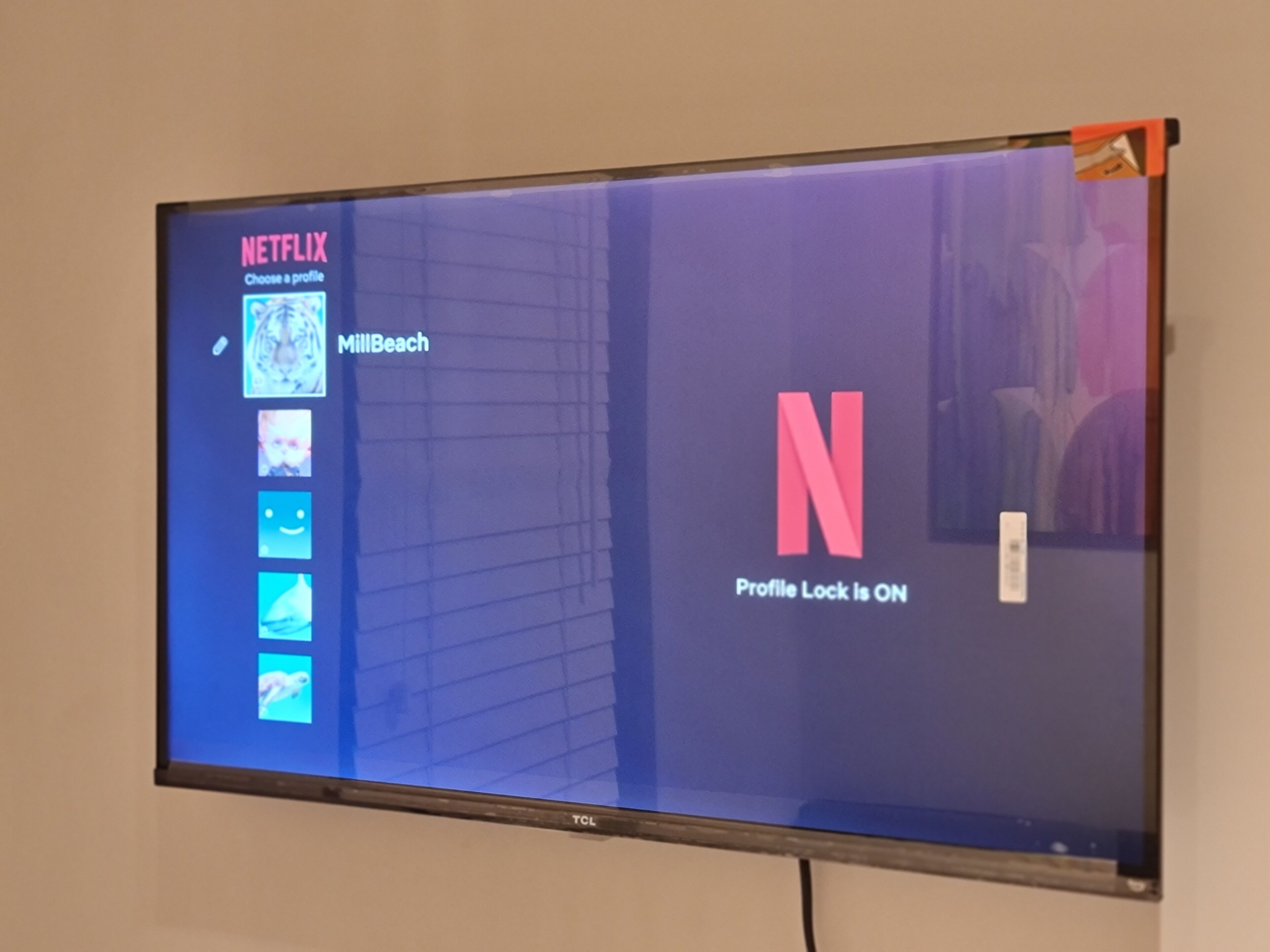 A television screen displaying the Netflix interface with a profile named "MillBeach" and a notification that "Profile Lock is ON."
