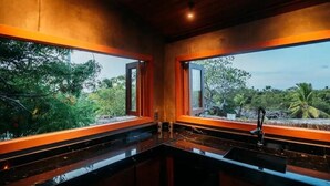 Cucina con un piano di lavoro nero e vista sul verde.