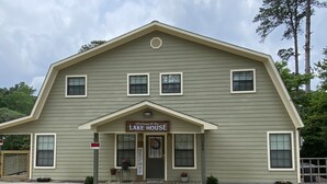 Un edificio a due piani con un cartello che dice 'Welcome to the Lake House'.
