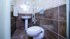 A bathroom with a toilet, sink, and towel rack. - SEYİR ROYAL (Kocasinan)