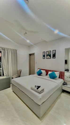 Relax in a spacious room with a large bed, bedside table, and comfortable seating area.