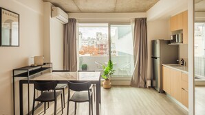 Apartament modern amb zona de menjador, cuina i finestra gran amb cortines.