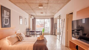 Un saló modern amb un sofà, una televisió i zona de menjador.