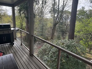 A balcony with a grill, overlooking a forested area. - Enjoy all the comforts of home in a safe, wooded area of NE Seattle, close to UW (Seattle)