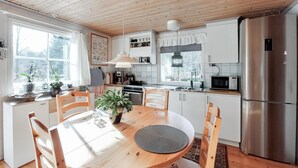 A modern kitchen with white cabinets, a stainless steel refrigerator, and a dining table with chairs. - Gorgeous home in örkelljunga with WiFi (Örkelljunga)