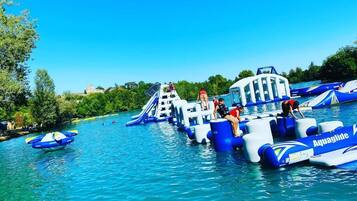 A water park with inflatable water rides and boats.