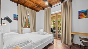A bedroom with a bed, a desk, and a chair. There is a window with curtains, a radiator, and a picture on the wall. - Nice home in Cabrunici (Cabrunici)