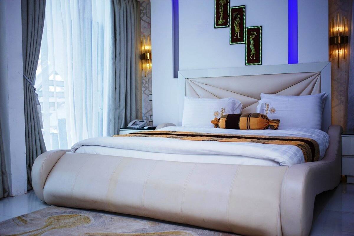 Ein modernes Schlafzimmer mit einem großen Bett, einem Nachttisch und einer Wandleuchte.