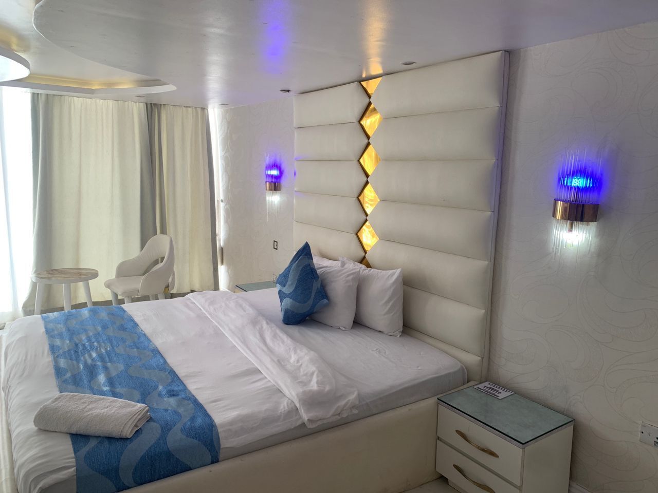 Une chambre d’hôtel moderne avec un grand lit, une table de chevet, une chaise et un bureau.