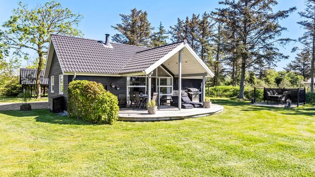 A house with a covered patio, a barbecue area, and a lawn. - 3 bedroom amazing home in Vestervig (Vestervig)