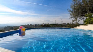 A swimming pool with clear blue water, a colorful beach ball, and a view of distant mountains. - Nice apartment in Moscufo with WiFi (Moscufo)