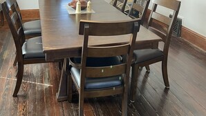 A dining room with a large wooden table, six chairs, a chandelier, and a framed picture on the wall. - The Adolphus - 4 Bedrooms, 2 Baths. Sleeps 8 comfortably!  (Oak Harbor)