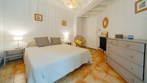 A bedroom with a bed, bedside tables, a chair, a dresser, and a radiator. - Capbreton Villa au Domaine de la Cigalière Pour 4 Personnes (CAPBRETON)