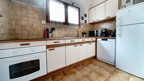 A kitchen with white cabinets, a stove, a microwave, and a dishwasher. - Capbreton Villa au Domaine de la Cigalière Pour 4 Personnes (CAPBRETON)