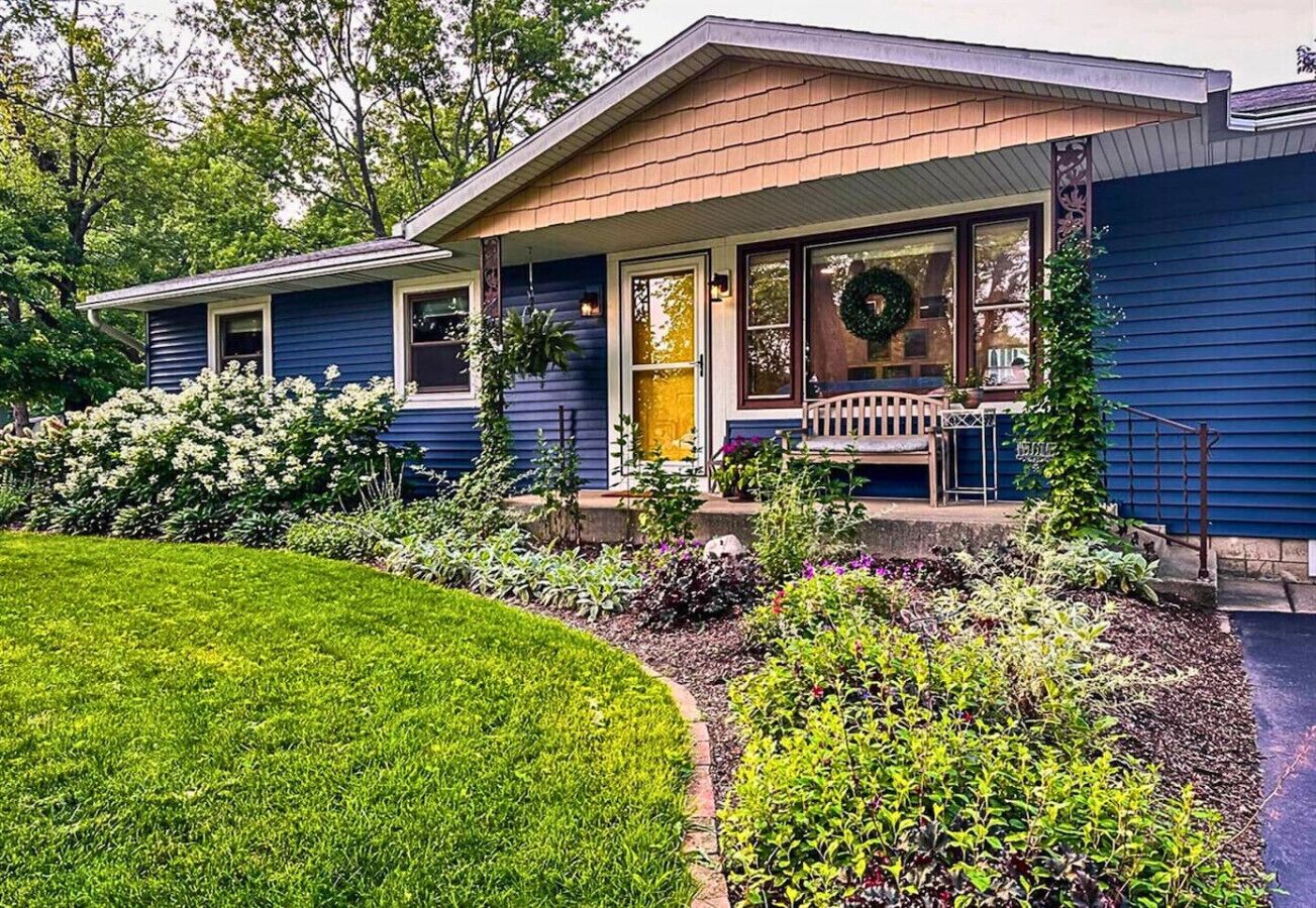 A two-story house with a front porch, a wreath on the door, and a well-maintained garden.