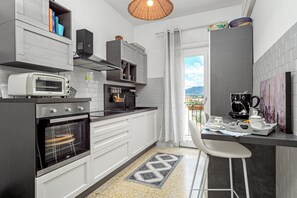 Eine moderne Küche mit Einbauofen, einer Kaffeemaschine und Blick ins Freie.