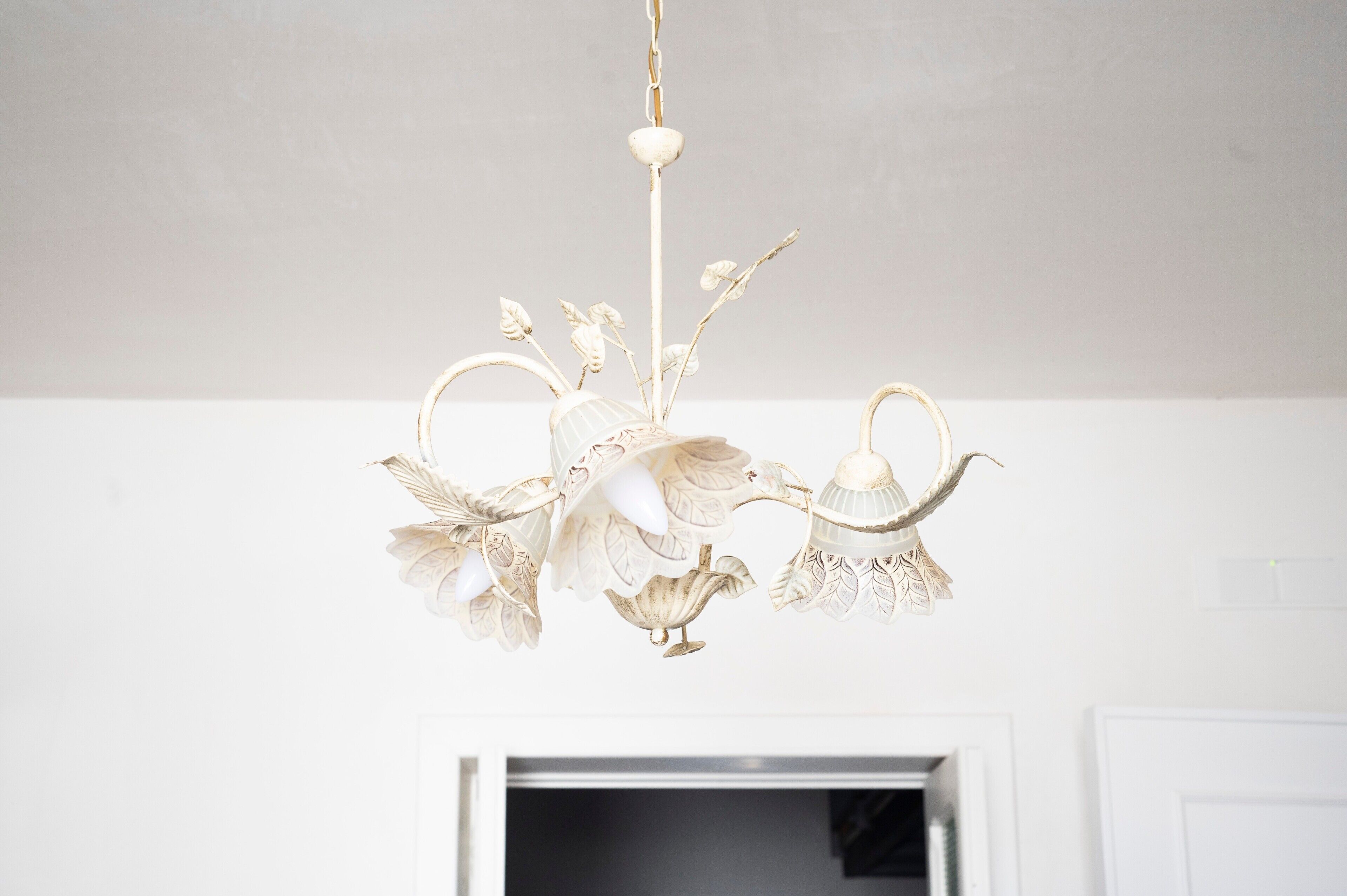 Ein weißes, verziertes Chandelier hängt von der Decke.