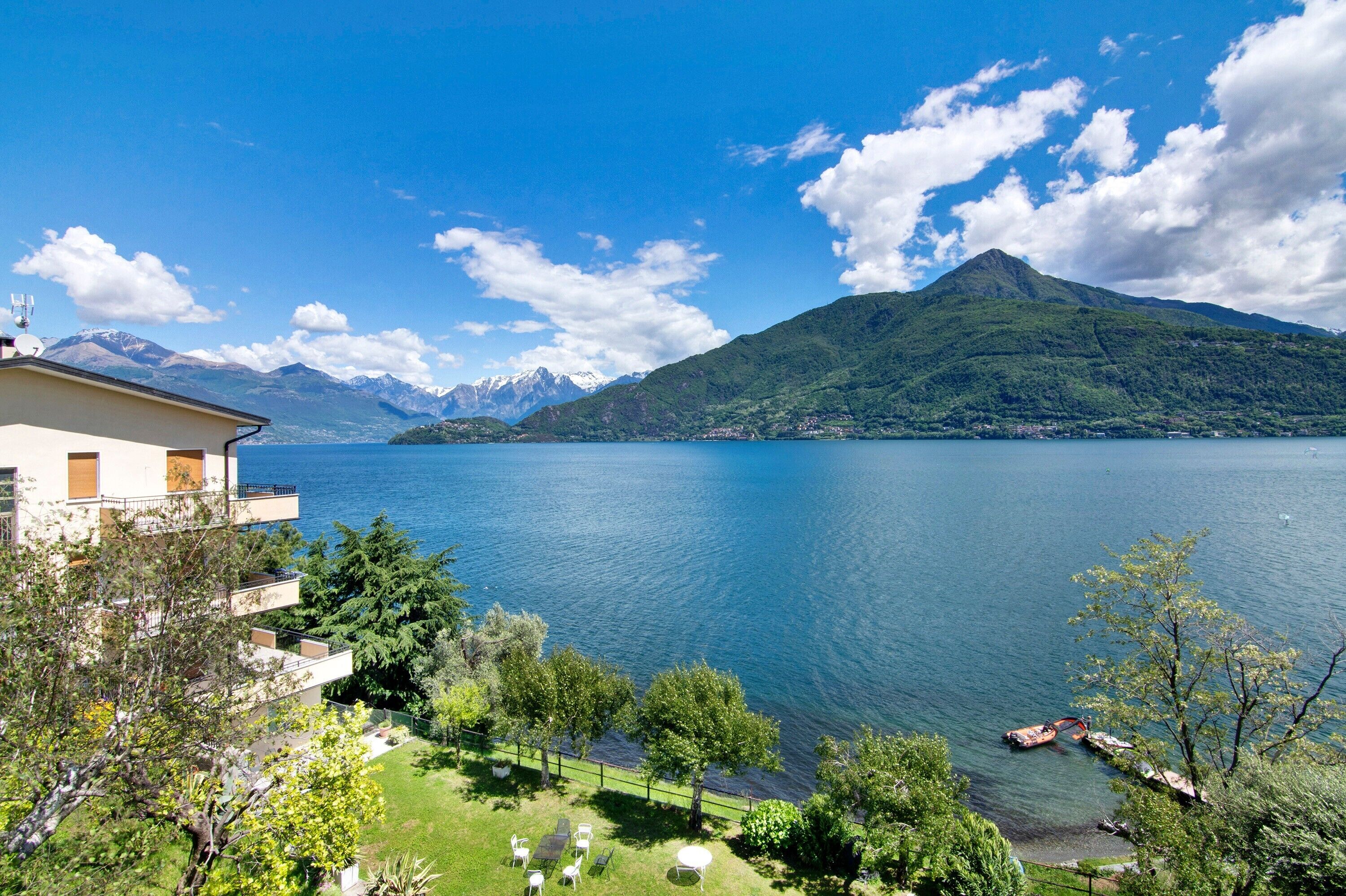 Una proprietà sul lago con vista sulle montagne, una piscina e un giardino.