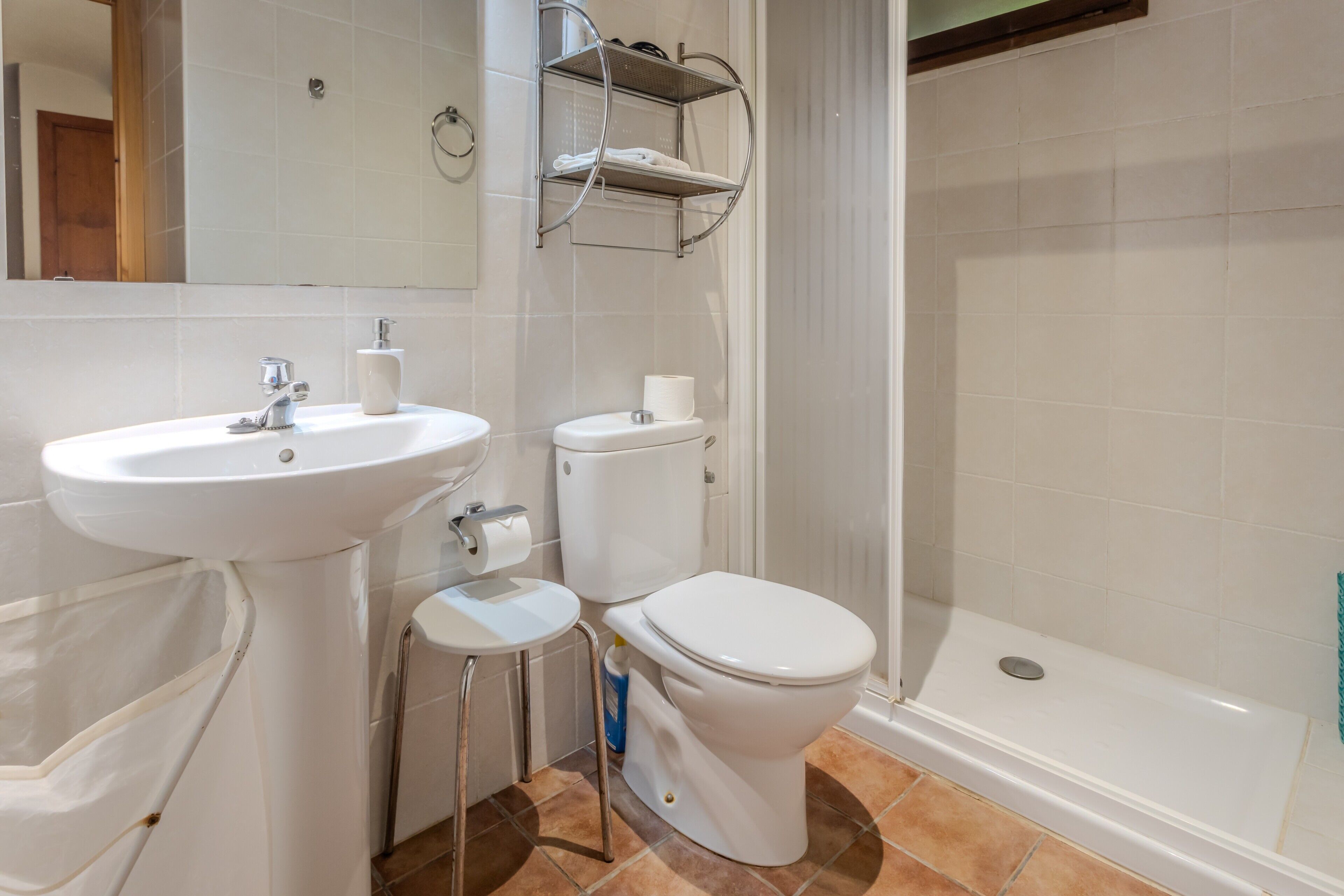 A bathroom with a sink, toilet, and shower.