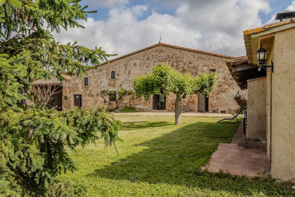 A stone building with a courtyard, a tree, and a lamp post.