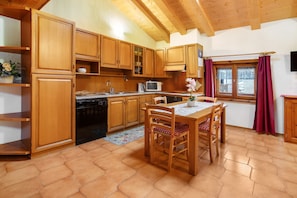 A kitchen with wooden cabinets, a microwave, and a dining table with chairs.