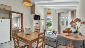 Une cuisine moderne avec des meubles en bois, une table à manger et un téléviseur fixé au mur.