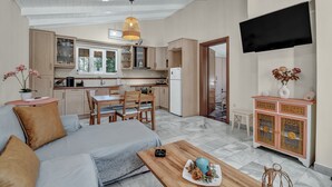 Un salon moderne comprenant un canapé, une table à manger et un coin cuisine.