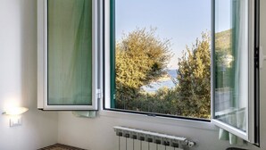 A room with a window, a radiator, and a wall-mounted light fixture. - Apartment 'La Realidad 4' with Shared Pool, Wi-Fi and Air Conditioning (Finale Ligure)