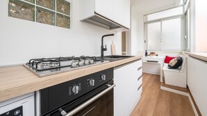 Una cocina moderna con estufa a gas, horno integrado y lavamanos.