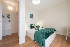 A bedroom with a bed, bedside tables, a desk, a chair, a wardrobe, and a painting on the wall. - Holiday Home 'Sa Mariposa' with Balcony, Wi-Fi and Air Conditioning (Cagliari)