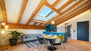 Un interior moderno con tragaluces, vigas de madera, un comedor y una cocina.