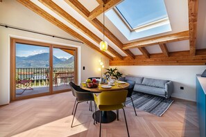 A dining area with a wooden ceiling, a round table, and chairs.