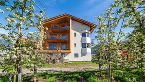 A multi-story building with balconies, surrounded by trees and a clear sky. - Apartment 'Villa Rosa Unterschöberlehof - Anna' with Mountain View, Wi-Fi and Air Conditioning (Meran)